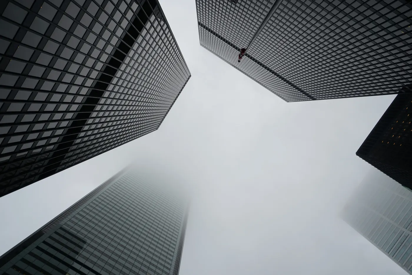 Looking up at glass skyscrapers in the fog